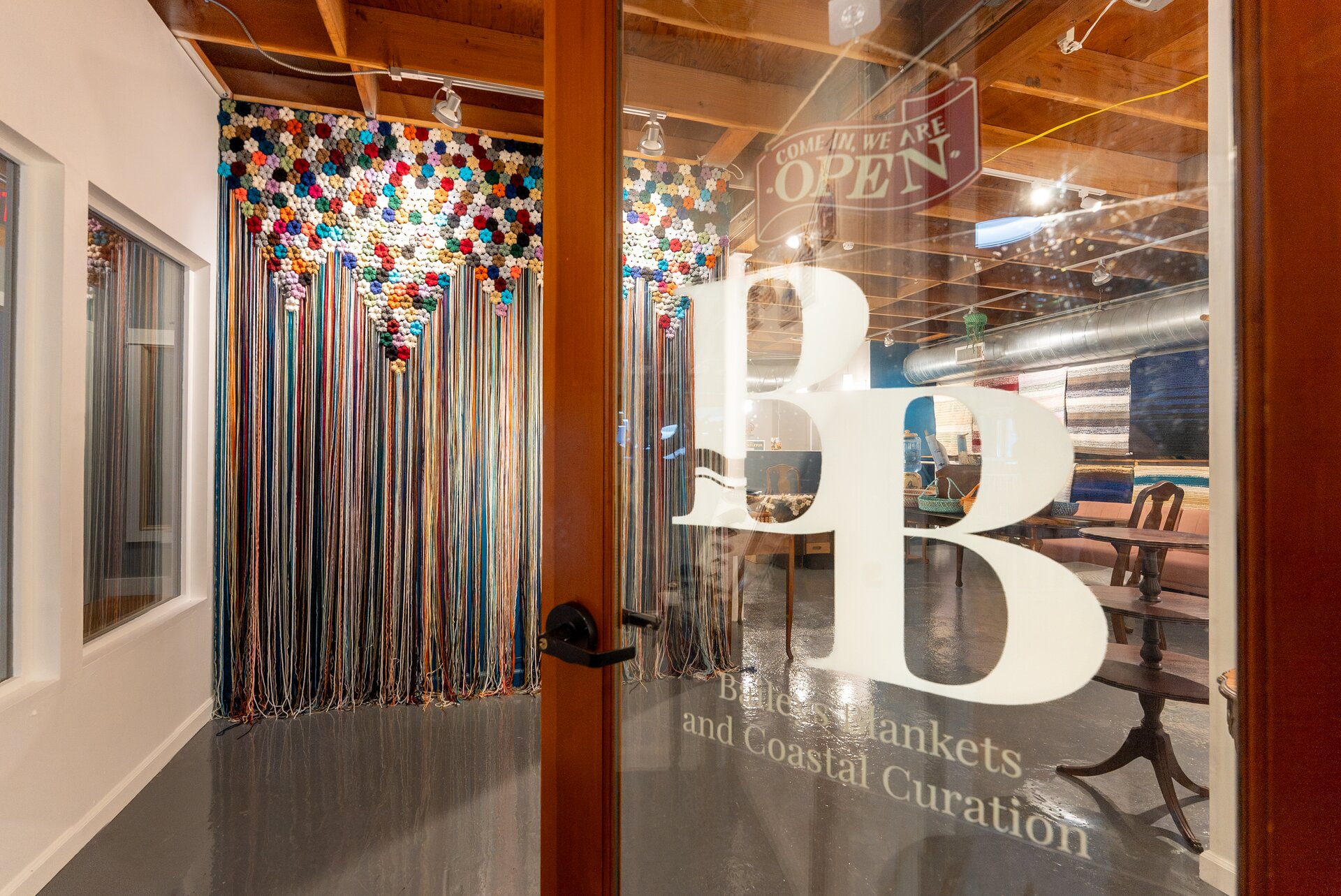 View into Bailey's Blankets through the etched glass door, crochet archway visible inside